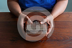 Woman holds Kalimba in her hands and plays it like a piano. Folklore musical instruments concept. Kalimba, acoustic music