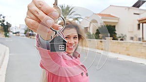 A woman holds the keys to a new home