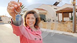 A woman holds the keys to a new home