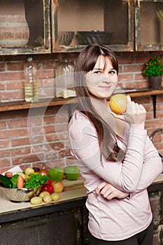 Woman holds an orange in her hand.Young Woman Cooking in the kitchen at home. Healthy Food. Diet.