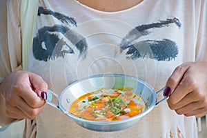 A woman holds panned egg in the hand photo