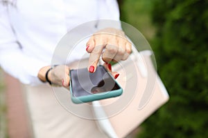 Woman holds phone in her hand and points finger at smartphone