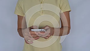 Woman holds phone looks at screen shows a yes gesture closeup