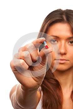 Woman holds a pill capsule in a hand