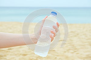 Woman holds a plastic bottle with clean drinking water in her hand