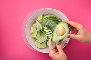 a woman holds a plate with a dietal avocado salad
