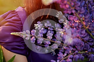 Woman holds purple lupins. Wellness closeness to nature. Self-discovery concept. Extra wide banner with copy space