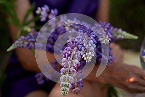 Woman holds purple lupins. Wellness closeness to nature. Self-discovery and connecting with nature concept.