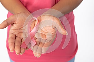 Woman holds ribbon in both hands for breast cancer awareness