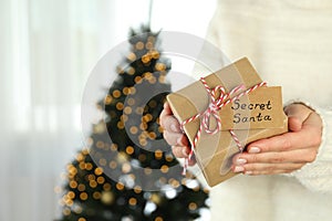 Woman holds Secret Santa gift box, space for text