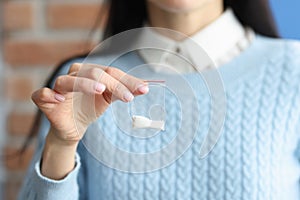 Woman holds small packet of white powder in her hands