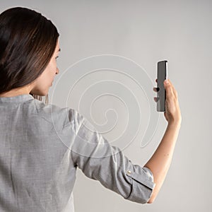 woman holds the smartphone in front of her eyes and unlocks the phone via face id.