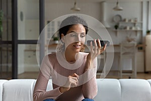 Woman holds smartphone near ear and listens audio message