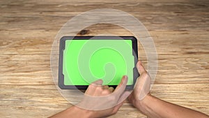 A woman holds a tablet PC with a green screen for your own custom content.