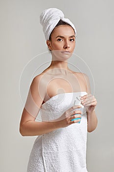 Woman holds tonic to remove makeup.