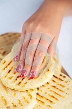 Woman holds Traditional Venezuelan food arepa made from cornmeal