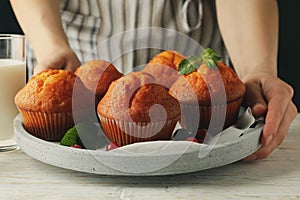 Woman holds tray with muffins close up. Muffins and milk