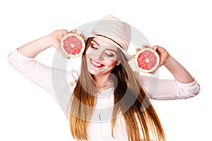 Woman holds two halfs of grapefruit citrus fruit in hands