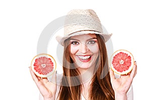 Woman holds two halfs of grapefruit citrus fruit in hands