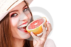 Woman holds two halfs of grapefruit citrus fruit in hands