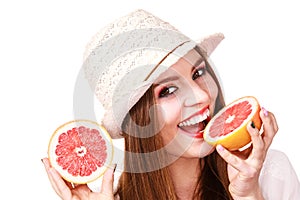 Woman holds two halfs of grapefruit citrus fruit in hands