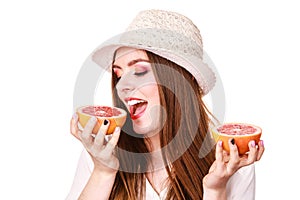 Woman holds two halfs of grapefruit citrus fruit in hands