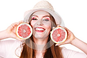 Woman holds two halfs of grapefruit citrus fruit in hands