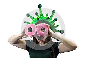 Woman holds two rolls of toilet paper in hand, looks at them like with binoculars. Virus, epidemic, quarantine, isolated