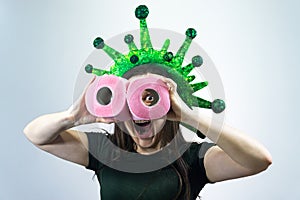 Woman holds two rolls of toilet paper in her hands and looks at them like with binoculars. Virus, epidemic, quarantine