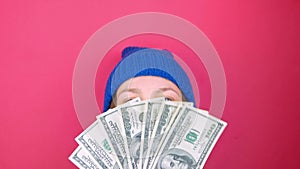 Woman holds US Dollars money bills pink background. Girl counting cash american 100 USD banknotes. Earning saving USA currency