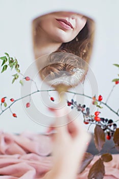 Woman holds vintage hand mirror