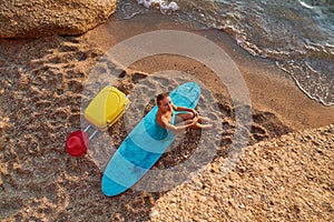 Woman on holiday, bright suitcase, surfboard and cap. Summer time, desire of adventure, time to relax and tourism idea