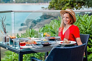 Woman on holiday vacation savors delicious dinner in beach restaurant