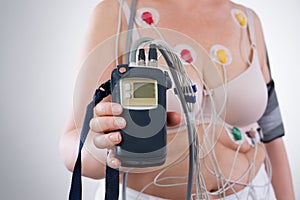 Woman with holter monitor device for daily monitoring of electrocardiogram and blood pressure