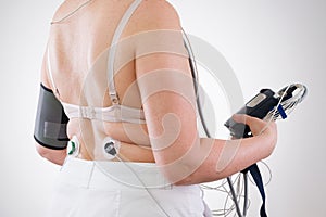 Woman with holter monitor device for daily monitoring of electrocardiogram and blood pressure