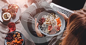 Woman in home clothes eating vegan Rice coconut porridge with figs, berries, nuts. Healthy breakfast ingredients. Clean eating,