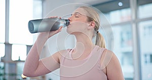 Woman, home and drink of water for sports break, energy and workout performance. Thirsty athlete, bottle and nutrition