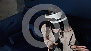 Woman at home experiencing virtual reality 3D games simulation entertainment activity wearing VR headset helmet at home