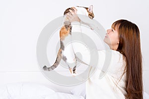Woman at home holding her lovely fluffy cat. Multicolor tabby cute kitten. Pets and lifestyle concept