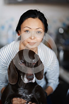 Woman at home hugging her dog