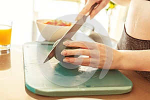 Woman in the home kitchen cutting an avocado for a healthy eating