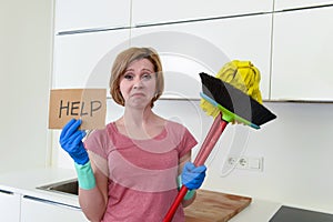 Woman at home kitchen in gloves with cleaning broom and mop asking for help