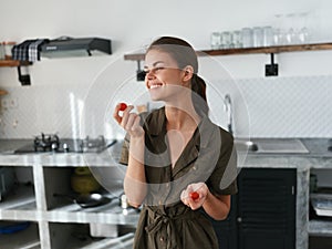 A woman at home in the kitchen prepares food using meat and vegetables, a large kitchen in a modern style, lifestyle