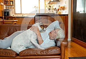 Woman at home loving and hugging her cute dog pet. Positive image of life at home and New Normal
