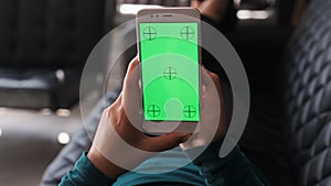 Woman at Home Lying on a Couch using Smartphone with Green Mock-up Screen. Girl Using Mobile Phone, Internet Social