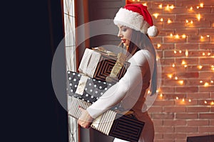 Beautiful girl standing near window with presents