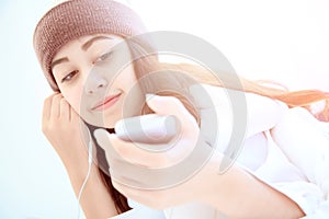 Woman at home reading a text message from smartphone in her bright bedroom