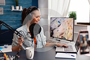 Woman in home studio recording podcast with mobile phone.
