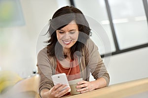 Woman at home using smartphone