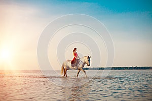 Woman and horse on the background of sky and water. Girl model o